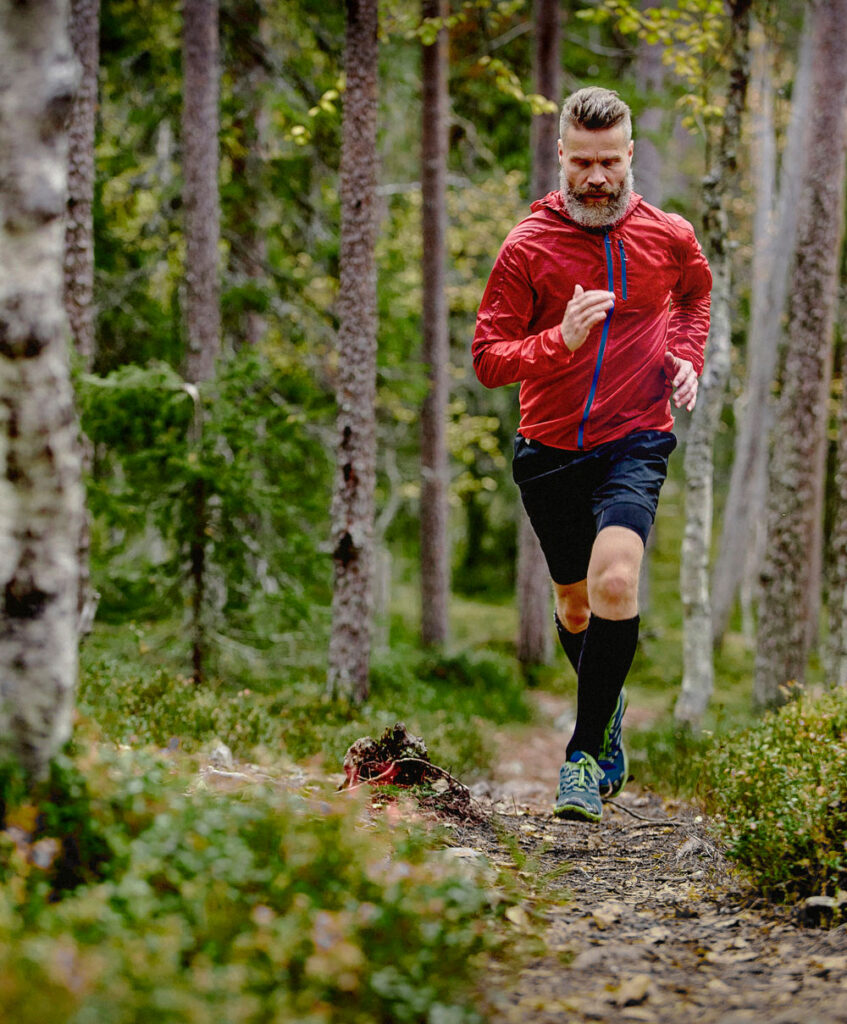 Man som springer i skogen